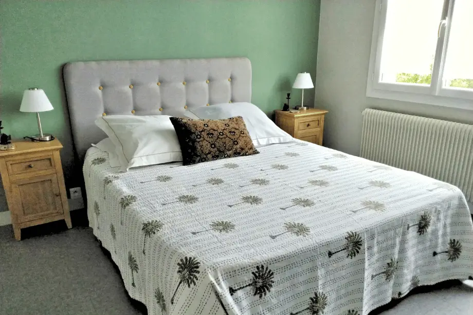 Chambre de la suite Watermael avec lit double et mur vert sauge
