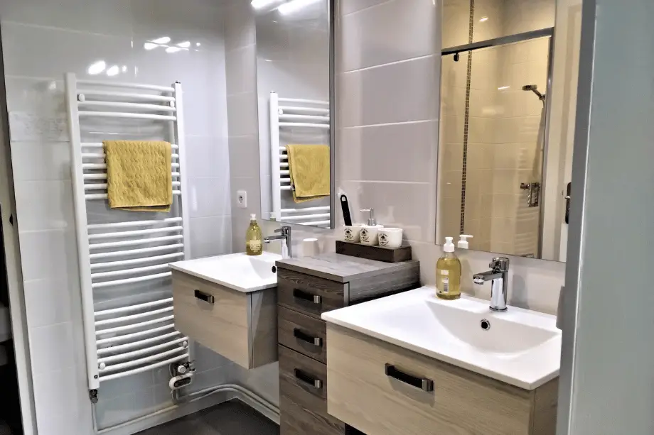 Salle d’eau de la suite Watermael avec double vasque, miroir et sèche-serviettes