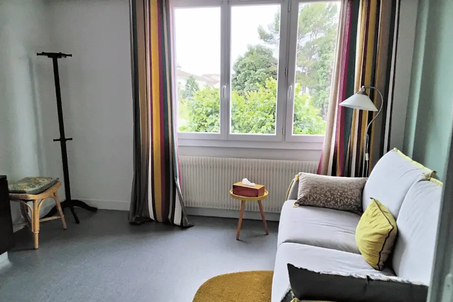 Salon privé de la suite Watermael avec canapé convertible et fenêtre donnant sur le jardin